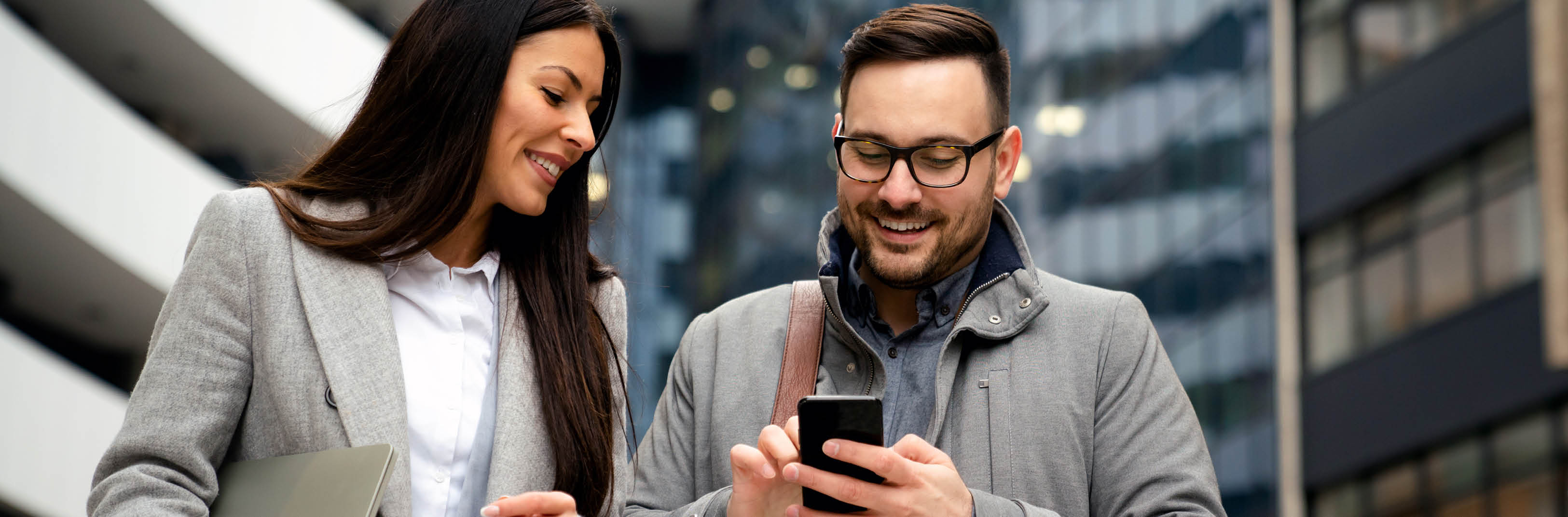 Man and Woman looking at phone smiling_844x279(ID#546494662 _AS)
