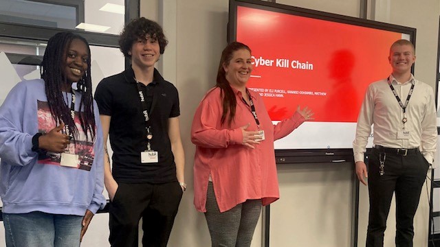 Four apprentices standing at the front of the room giving a presentation